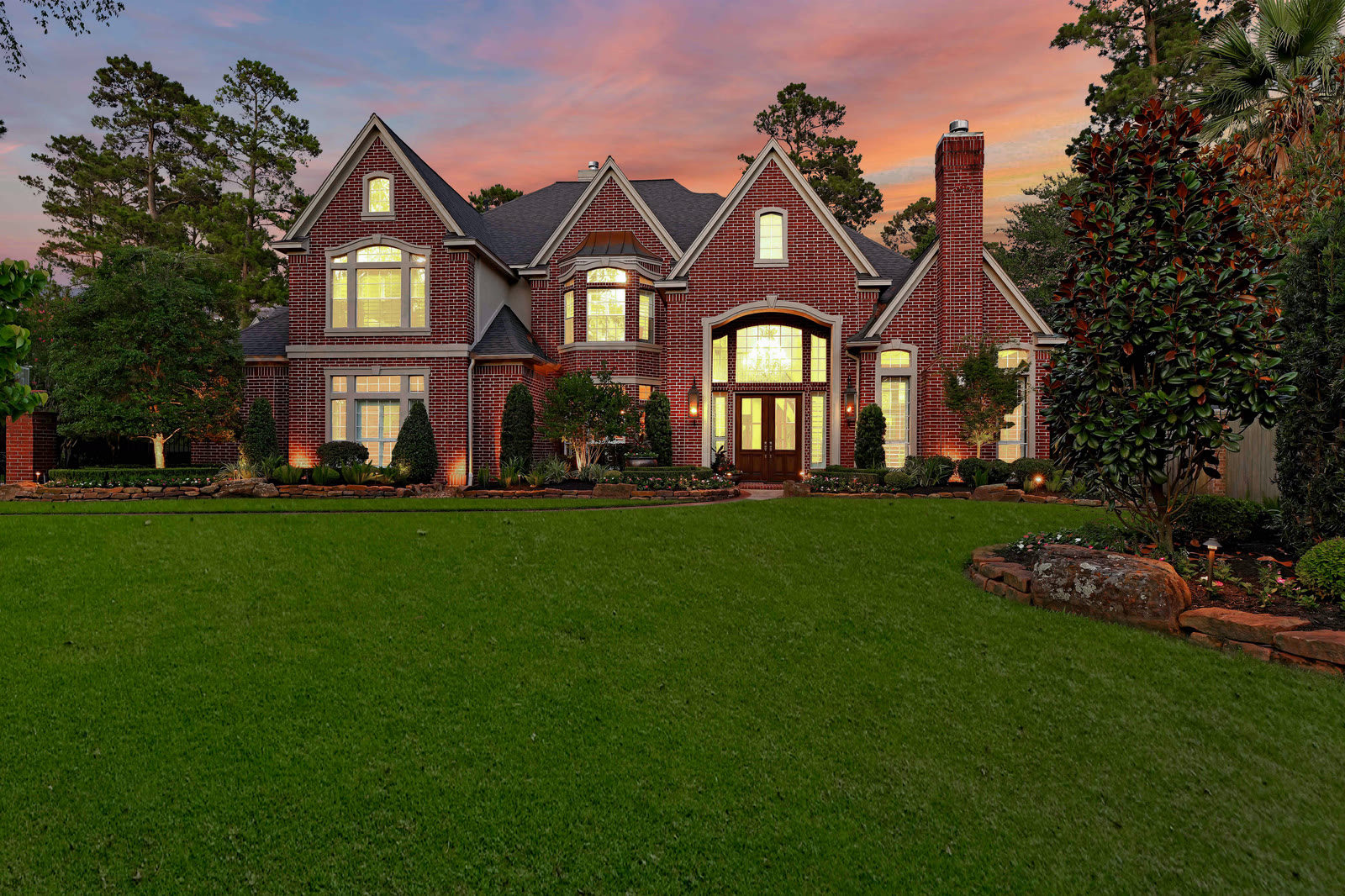 Large brick home photographed at twilight